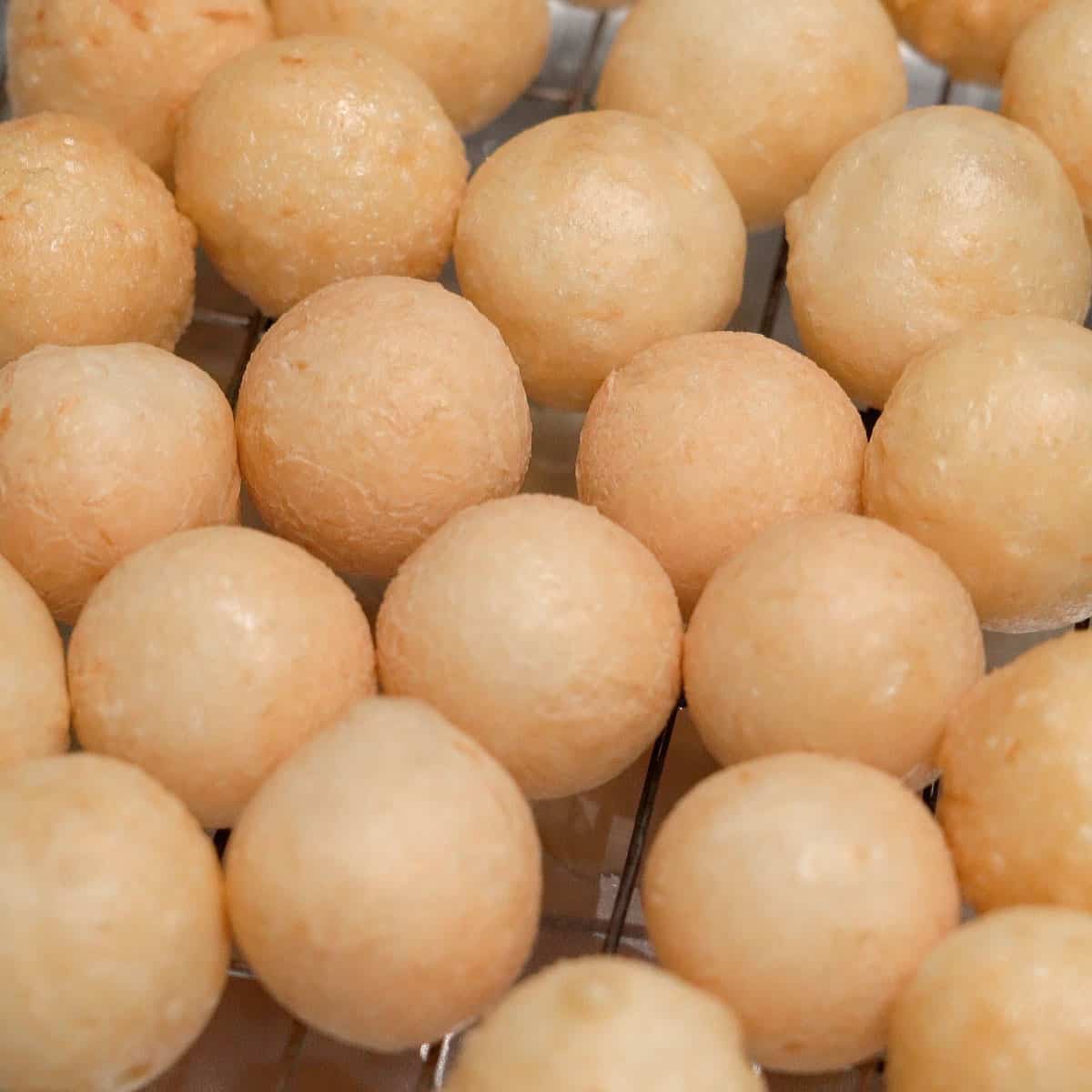 Fried carioca balls on a wire rack.