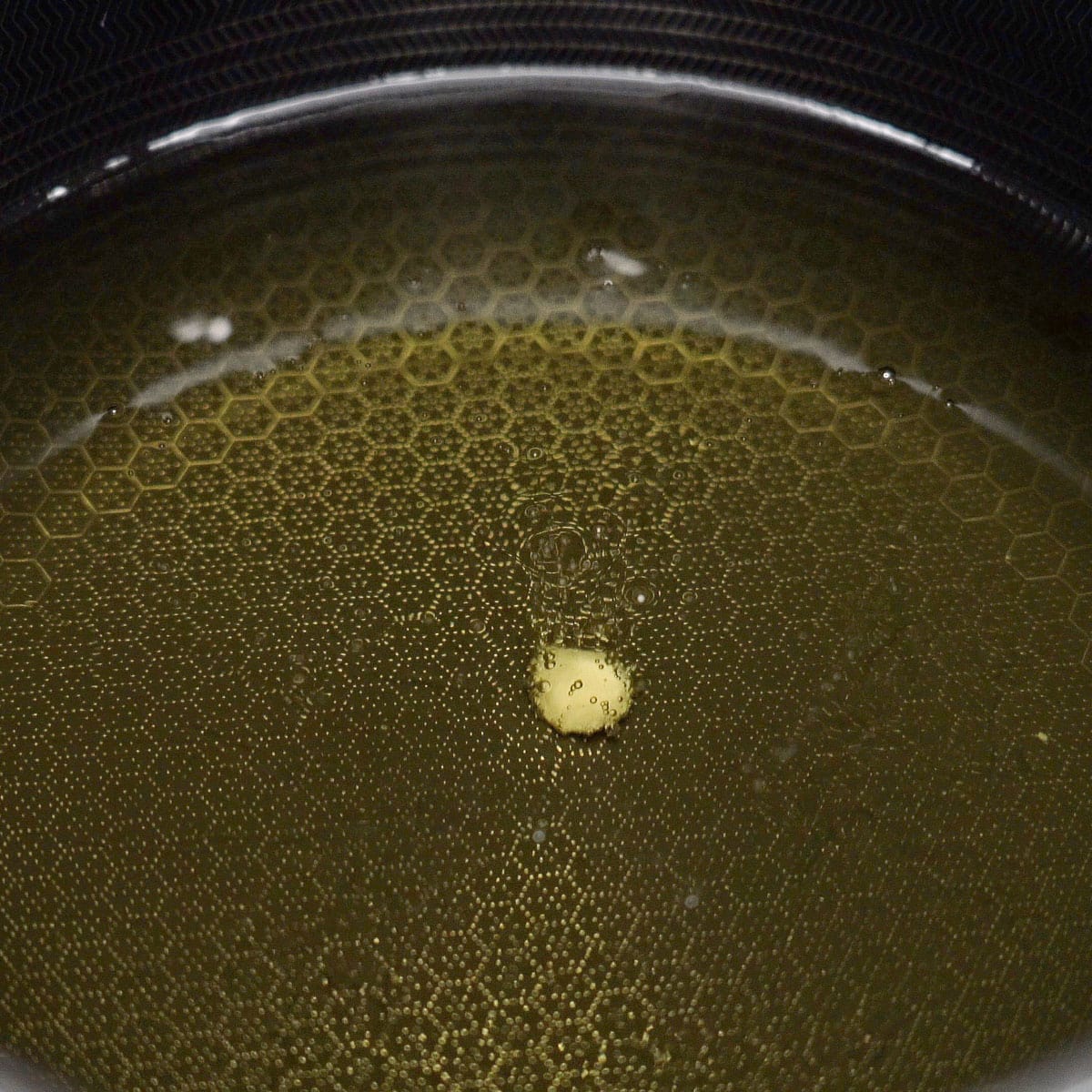 Frying a small piece of dough in oil.