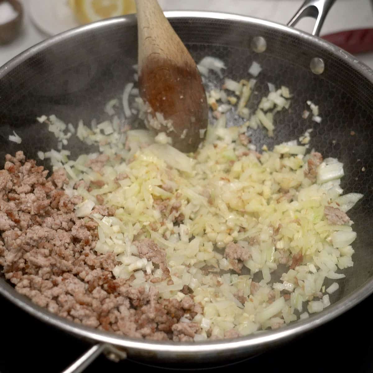 Sauteing aromatics with the browned pork on the side.