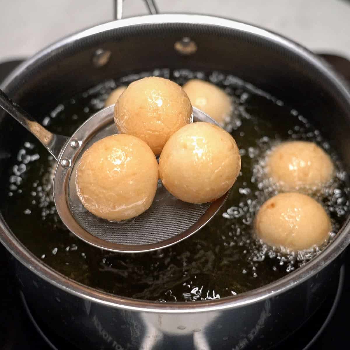 Draining the cooked carioca after frying.