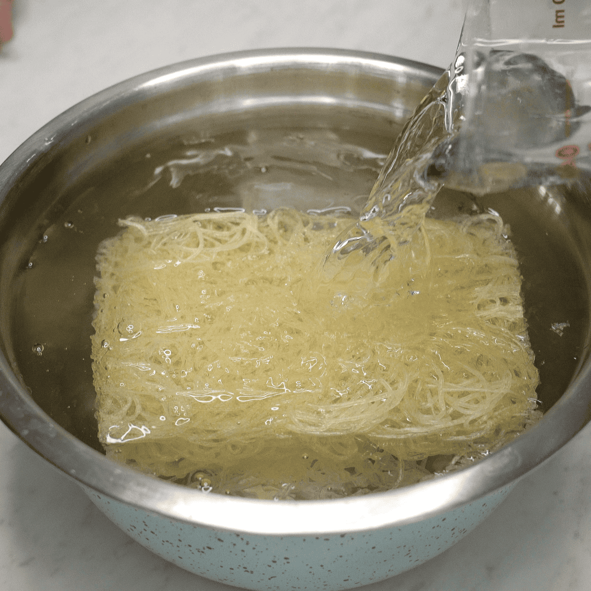 Soaking palabok noodles in water.
