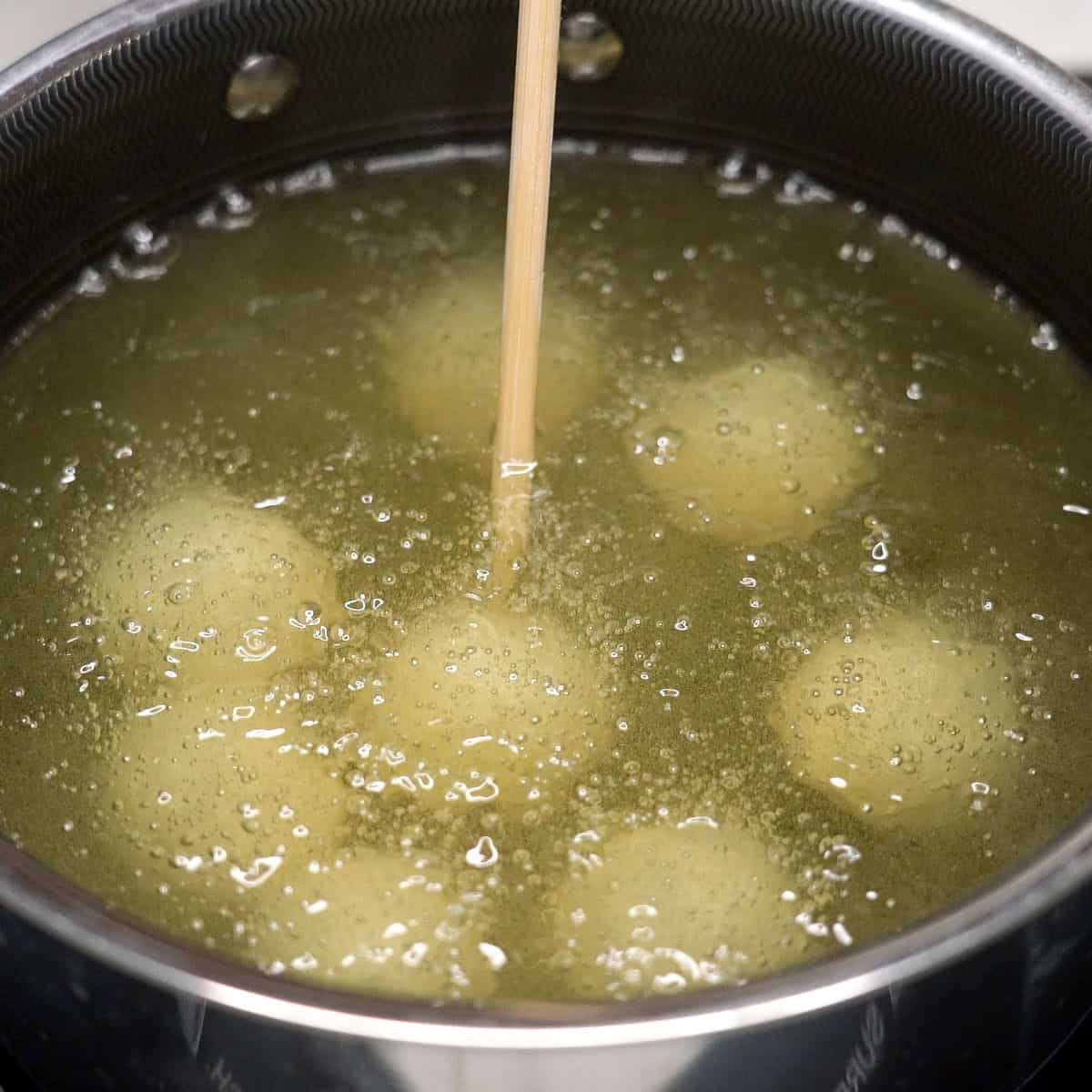 Stirring the carioca balls in the pot.