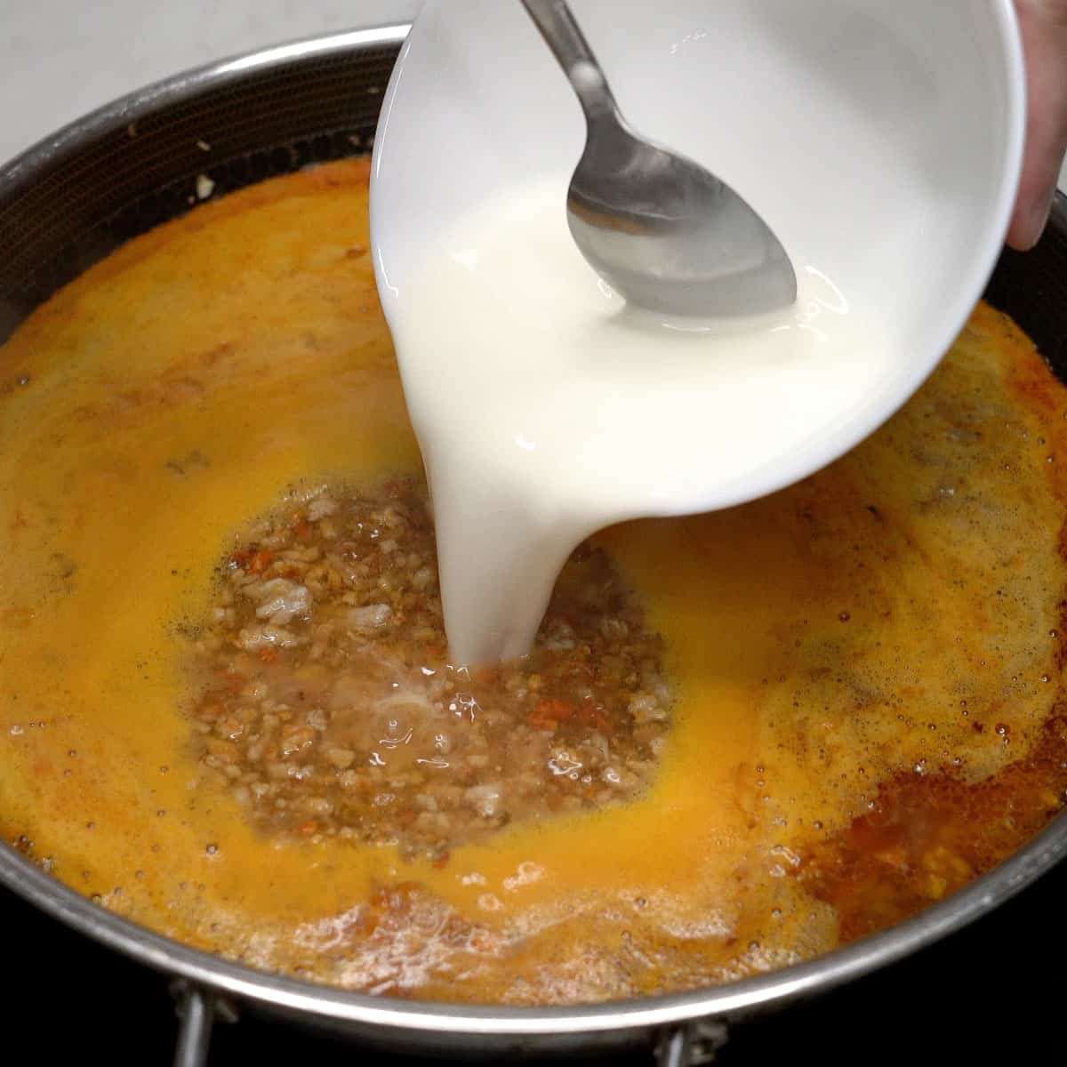 Adding the cornstarch slurry into the sauce.