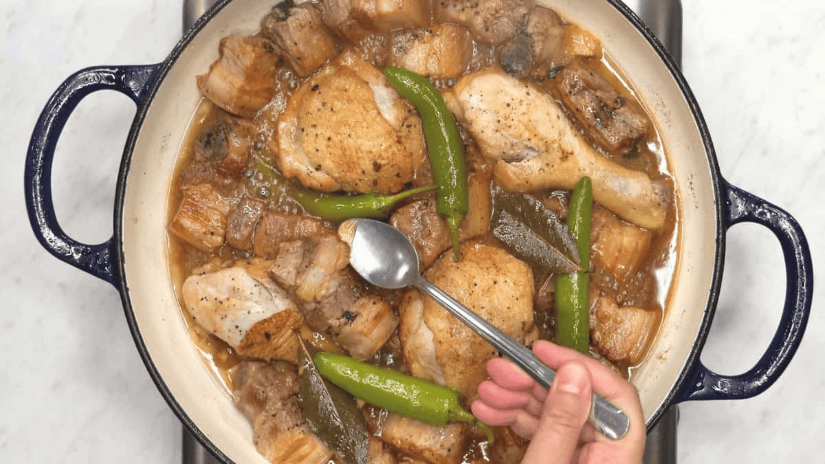 Tasting the sauce of Adobong Puti (White Adobo) using a spoon.