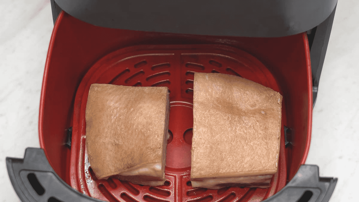 Pork belly pieces in the air fryer basket.