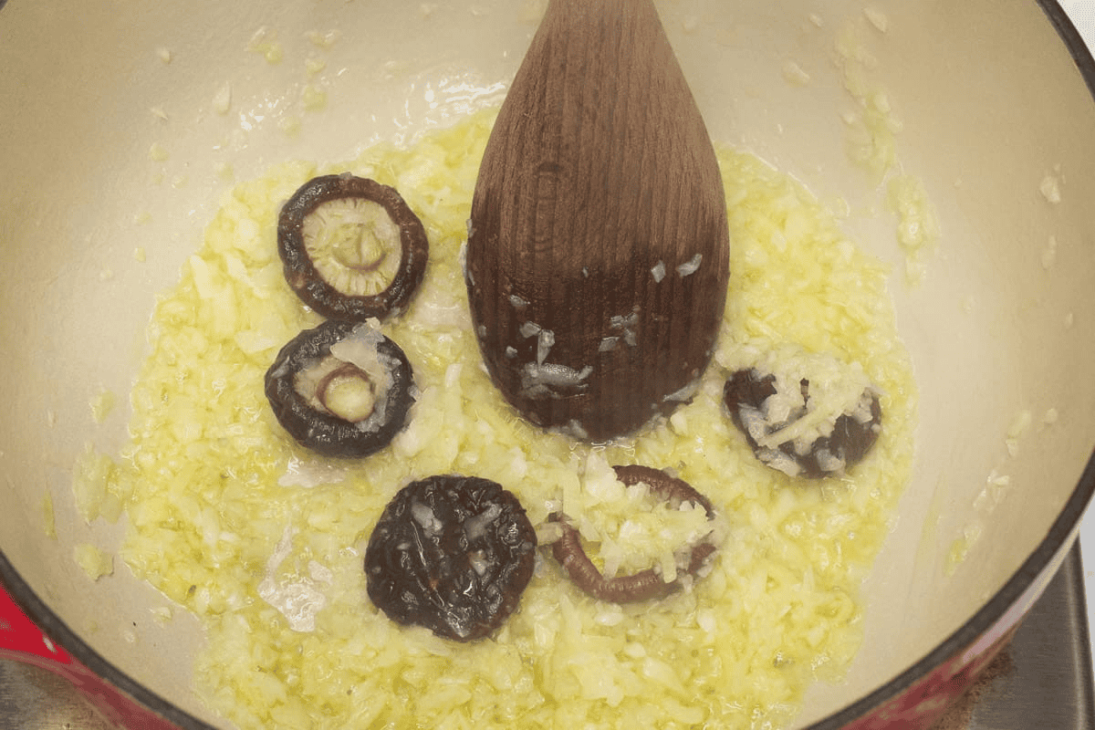 Sauteing the aromatics and shiitake mushrooms in the pot.