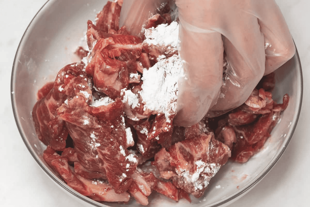 Marinating and velveting the beef in the bowl.