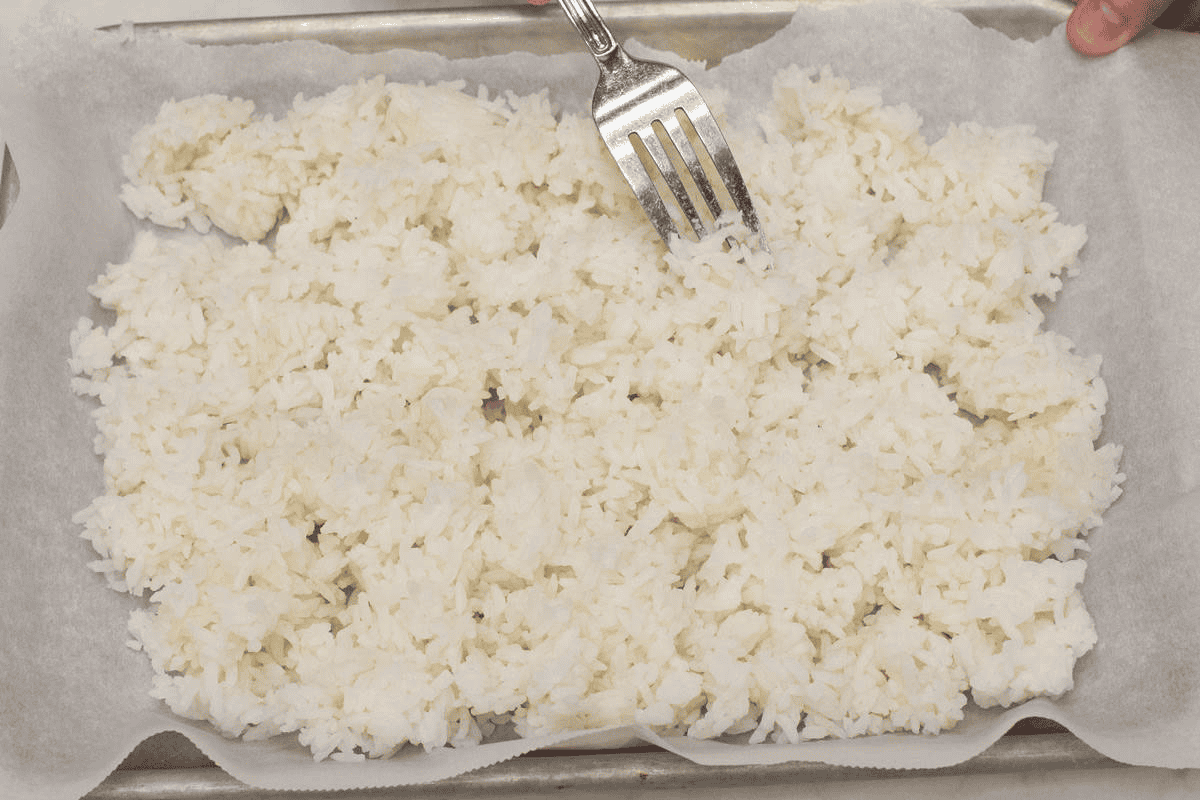 Breaking up the rice grains with a fork.