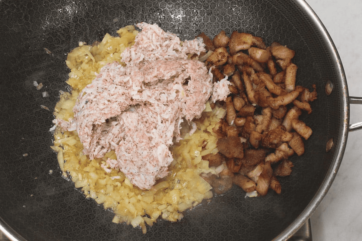 Rinsed shrimp paste with the aromatics and browned pork in the wok.