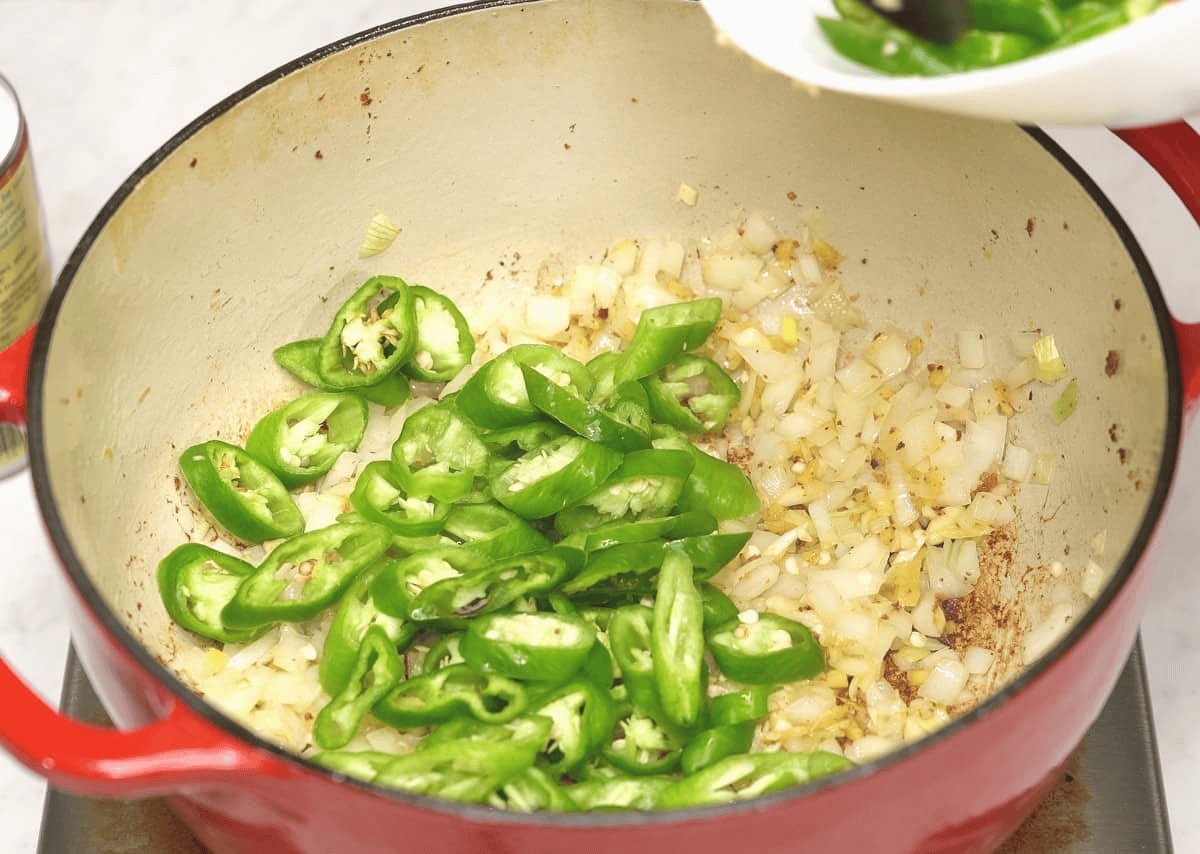 Sauteed aromatics and long hot peppers in the pot.