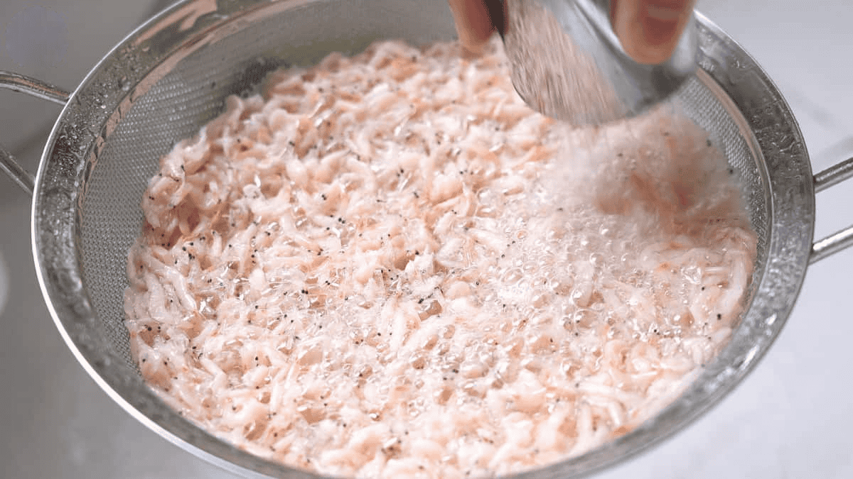 Rinsing raw shrimp paste on a sieve. 