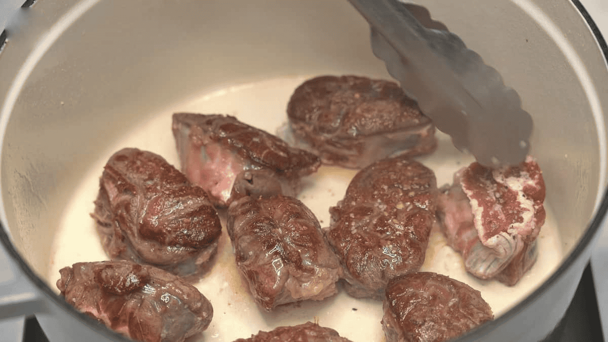 Searing the meat in a Dutch oven.