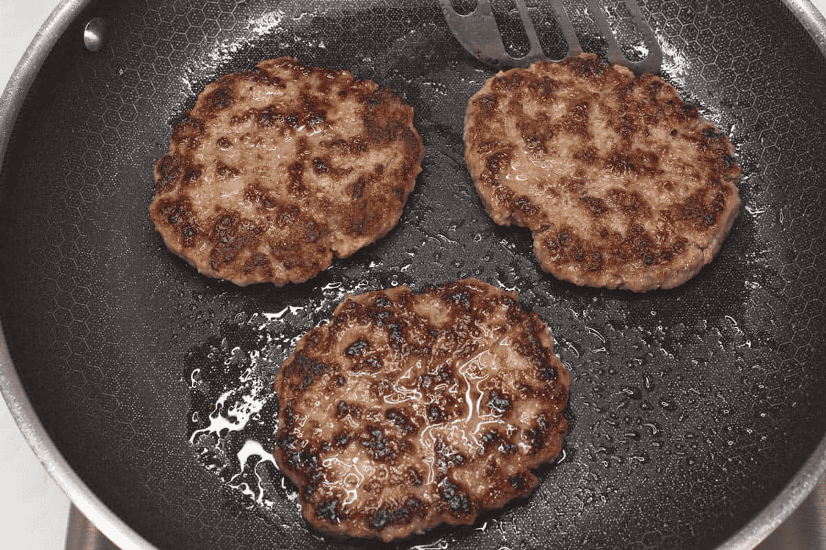 Cooking the patties in a skillet.