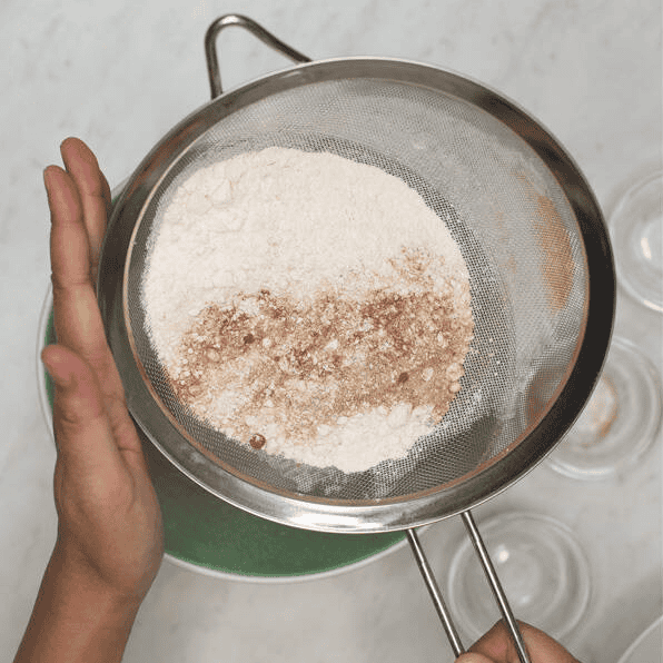 Sifting dry ingredients into a bowl.