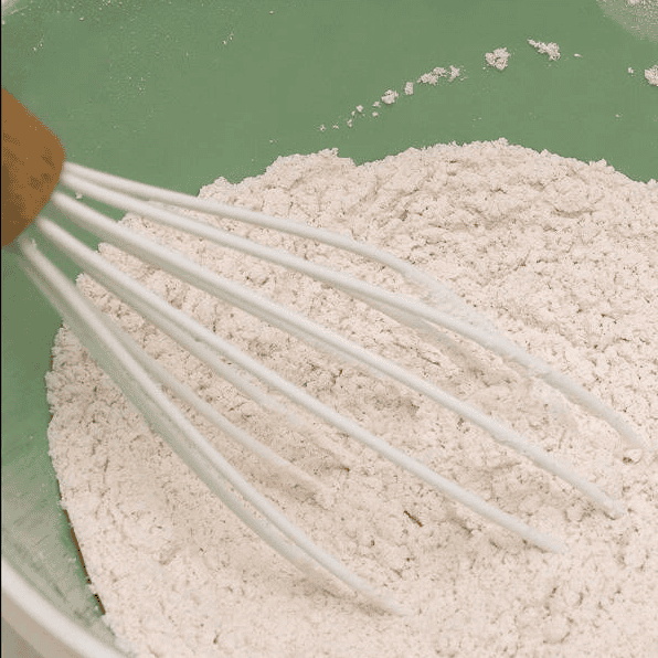 Whisking dry ingredients in a bowl.