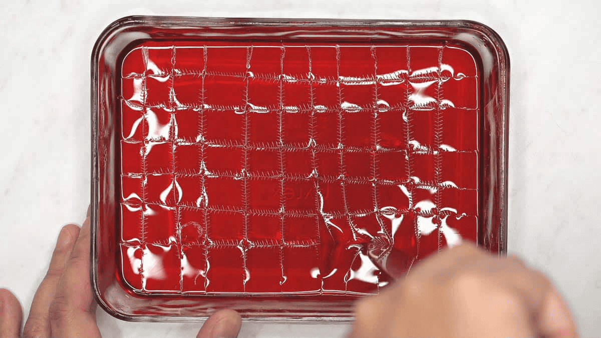 Cutting the gelatin in the container into small cubes.