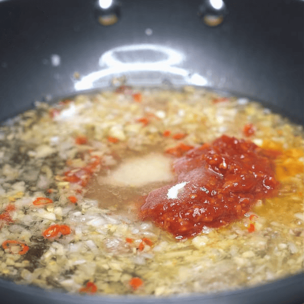 Sauteing aromatics and seasonings in a pan.