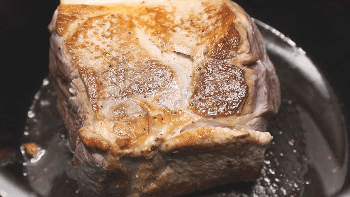 Searing the slab of meat.