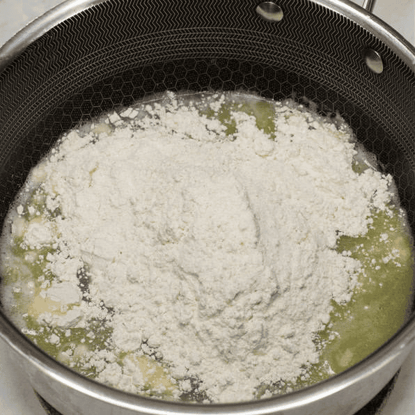 Adding flour to the hot water and butter for churros.
