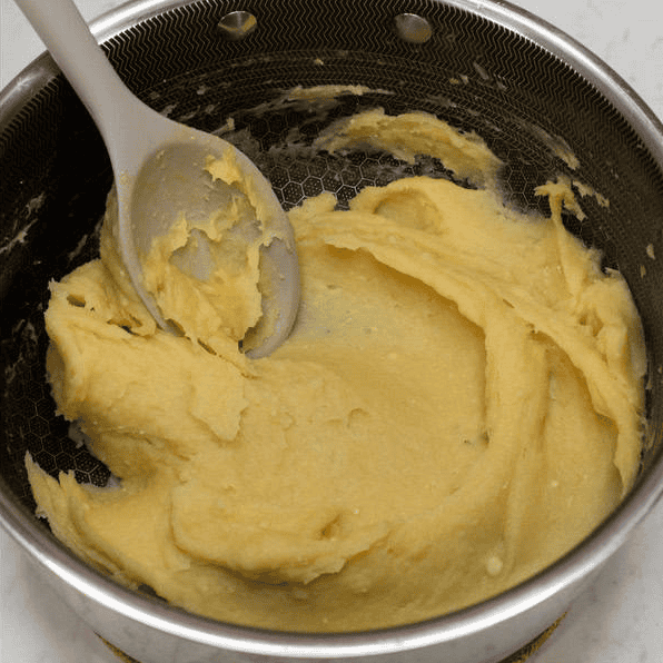 Mixing the egg into the churros dough until smooth.