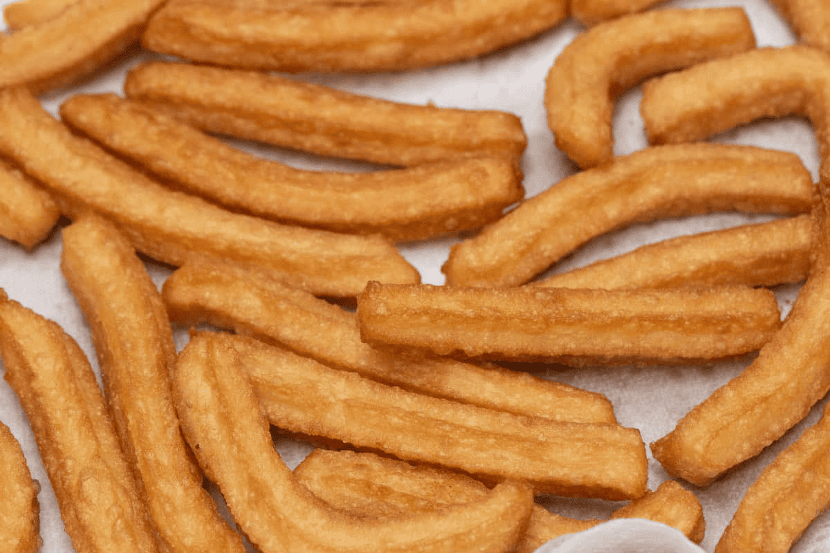 Draining the fried churros on paper towels.