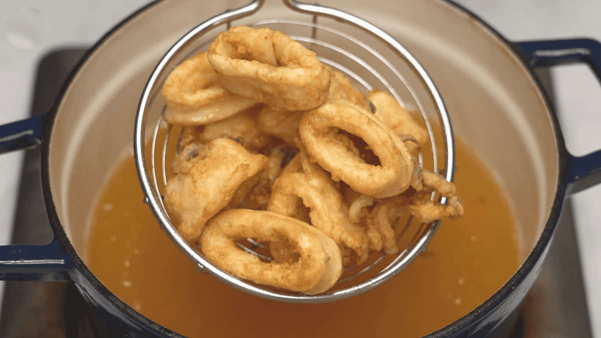 taking out the cooked calamari out of the oil