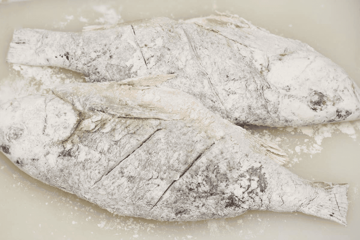 Two pieces of whole fish completely coated with starch.
