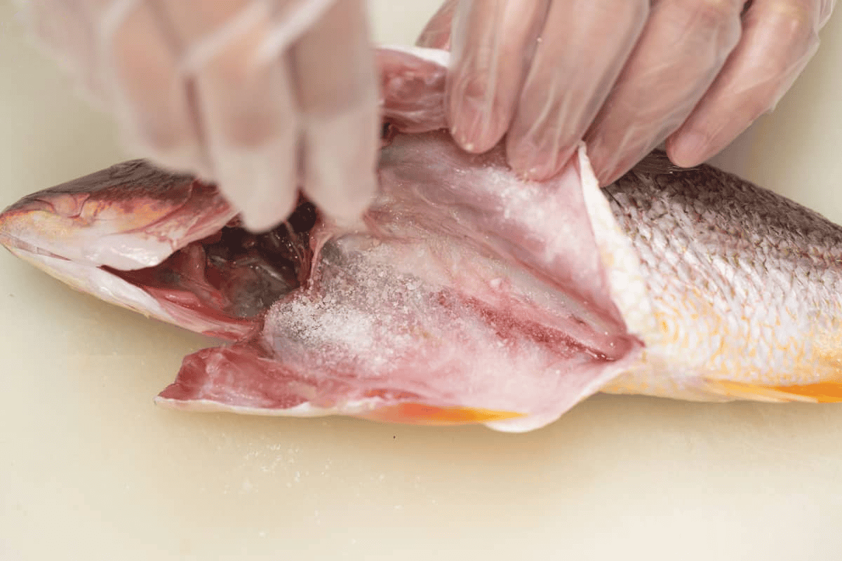 Seasoning the cavity of the fish with salt.