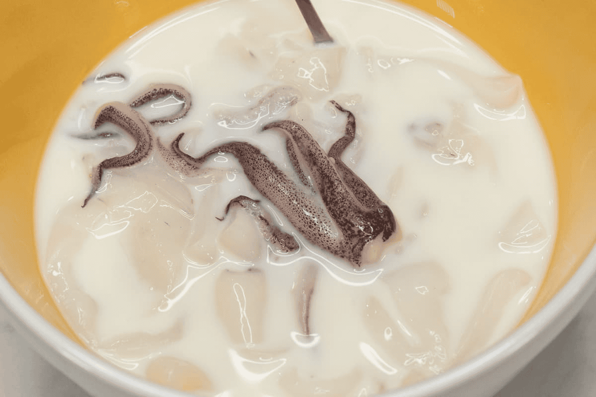 Soaking the pieces of squid in the milk mixture.