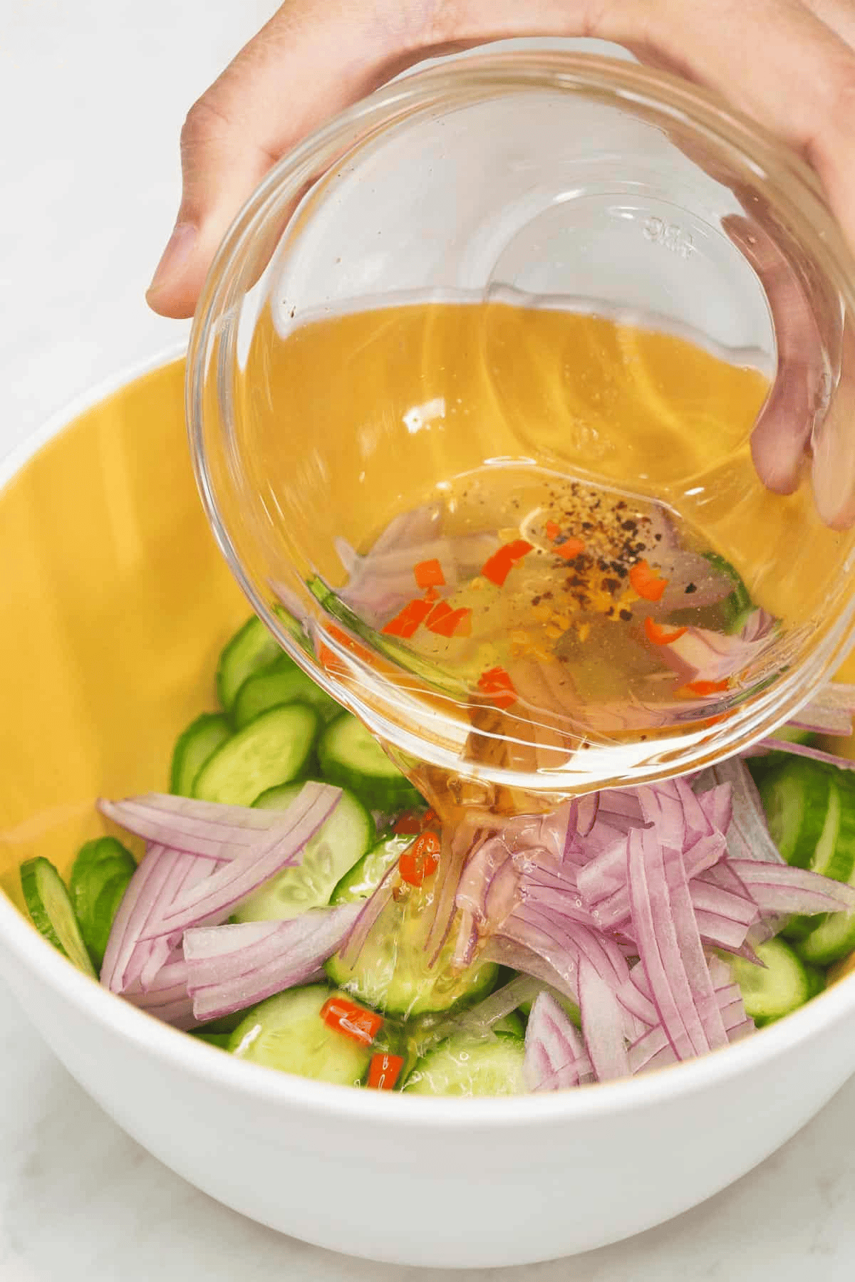 Pouring the dressing into the sliced vegetables.
