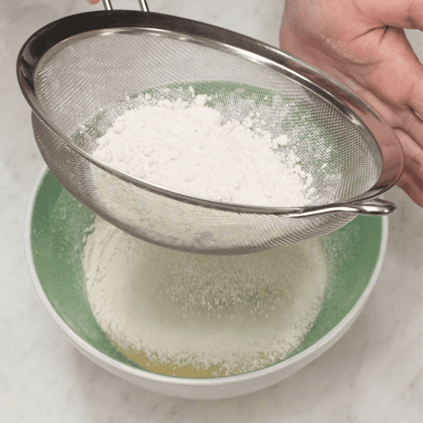 Sifting dry ingredients into the wet ingredients.