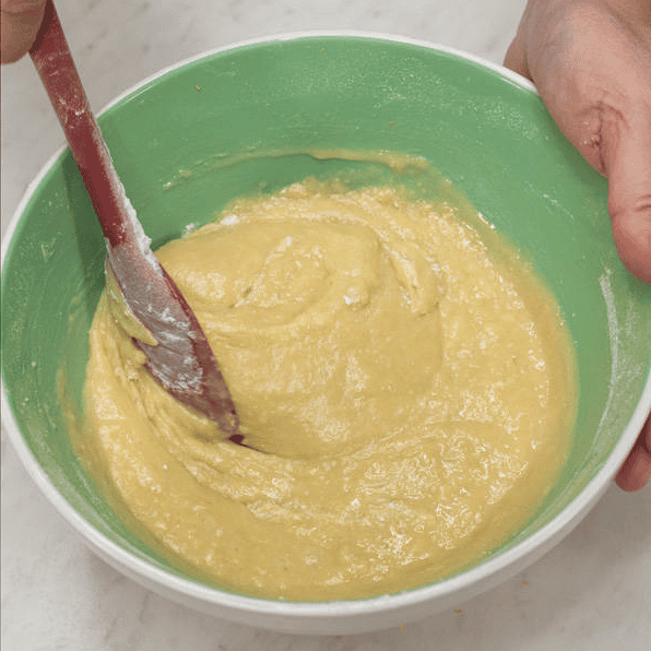 Folding the cake batter in a bowl.