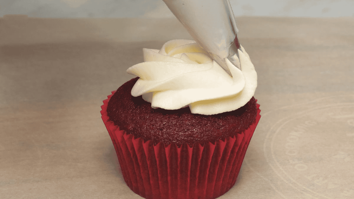 Frosting the cupcake.