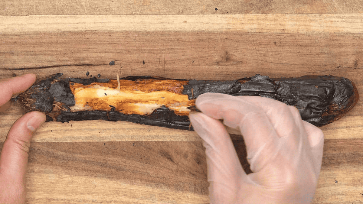 Peeling the charred skin of the eggplant.