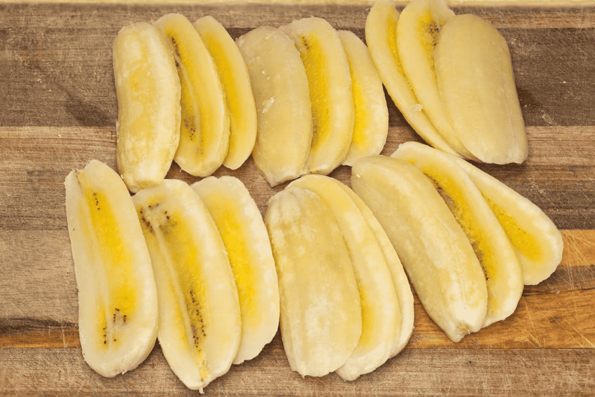Sliced saba bananas on a cutting board.