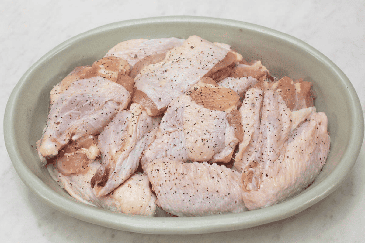 Seasoned pieces of chicken on a platter.