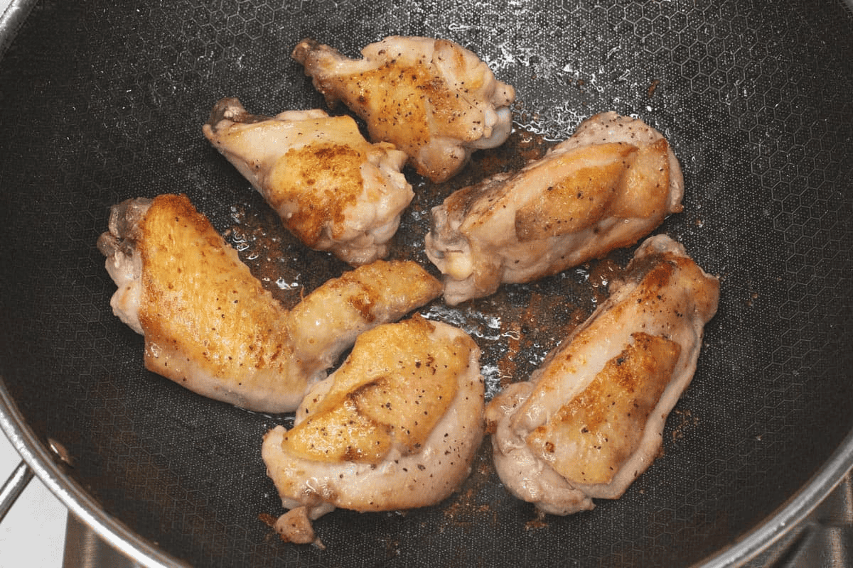 Searing the chicken in a wok.