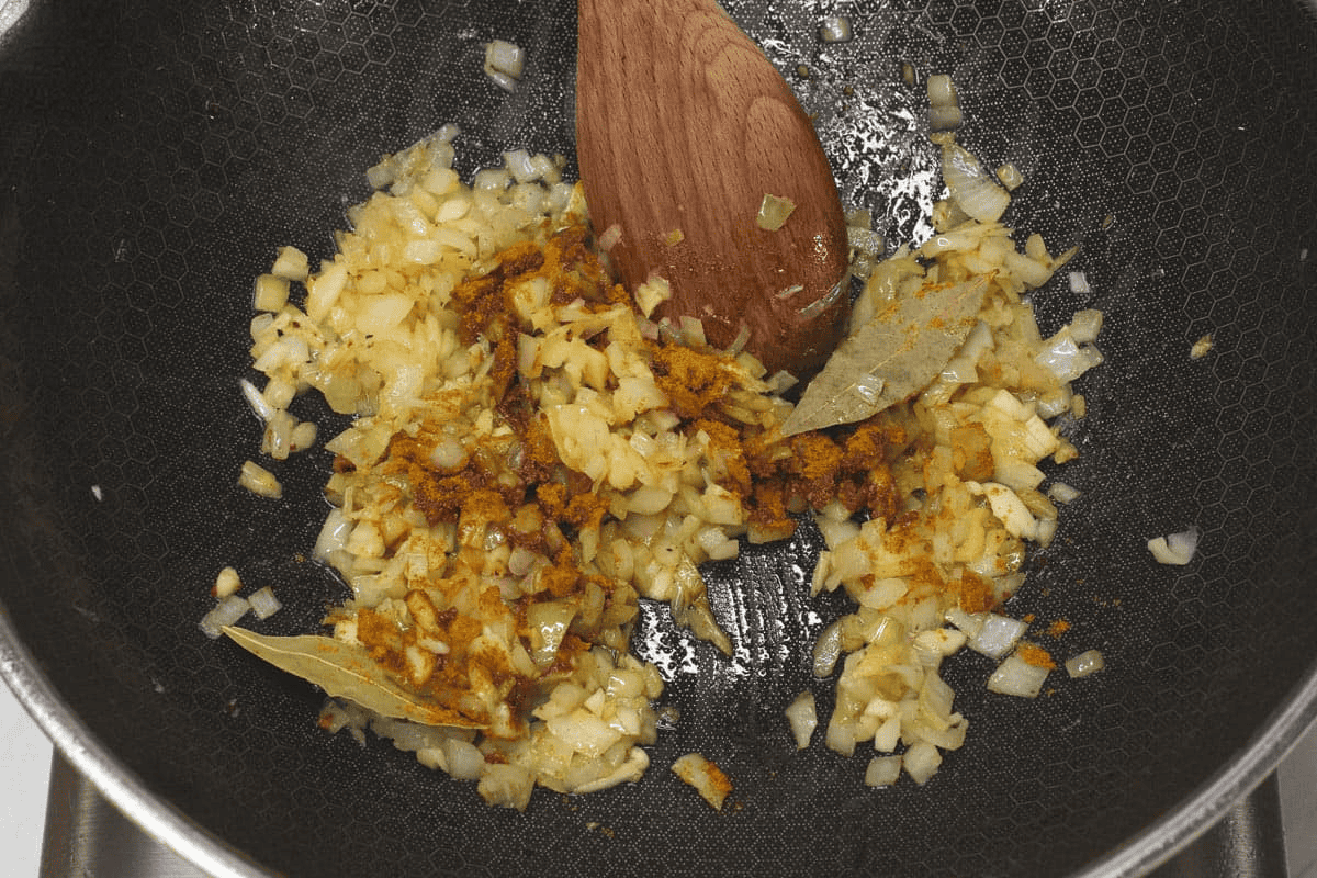 Blooming the curry powder with the aromatics in the wok.