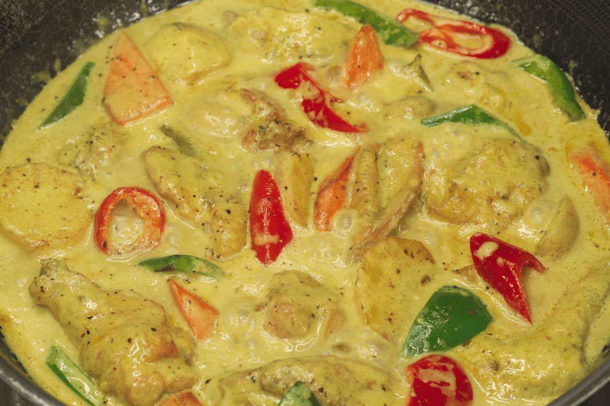 Simmering the chicken and vegetables in the wok.
