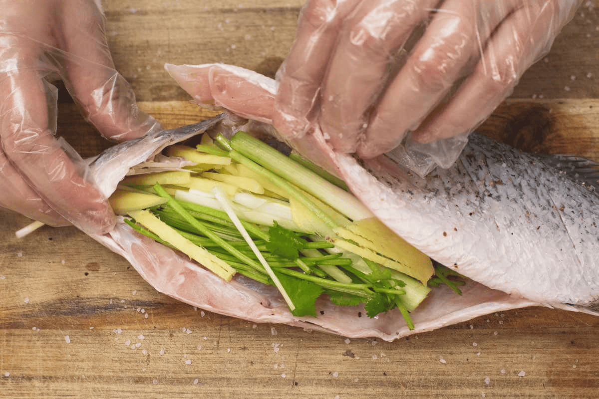 Stuffing the fish with aromatics.