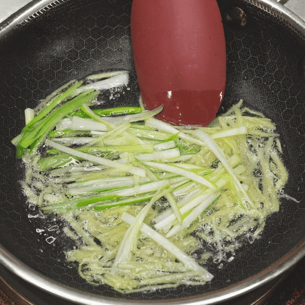Sauteing ginger and scallions in oil.