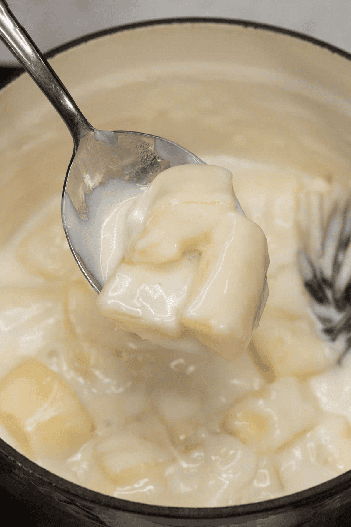 Scooping a portion of Ginataang Kamoteng Kahoy (Cassava with Coconut Milk).