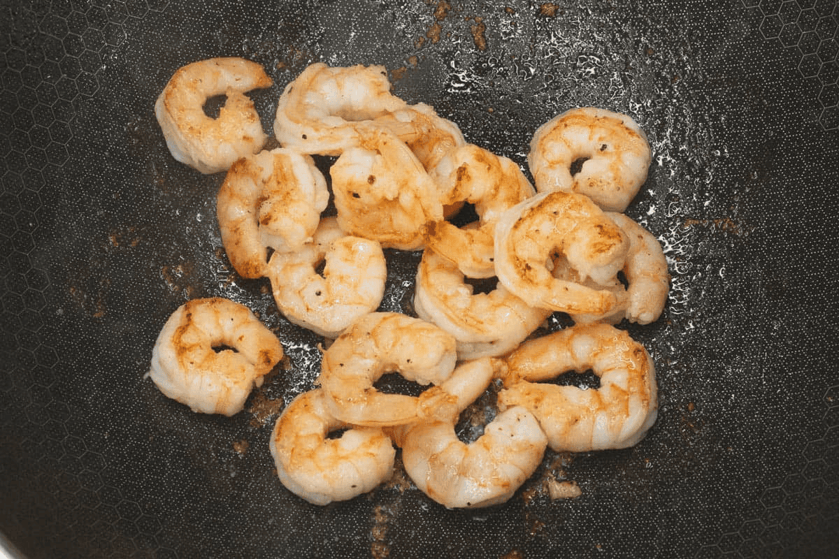 Searing the shrimp in a wok.