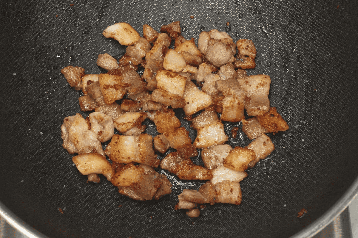 Browning the pork in a wok.