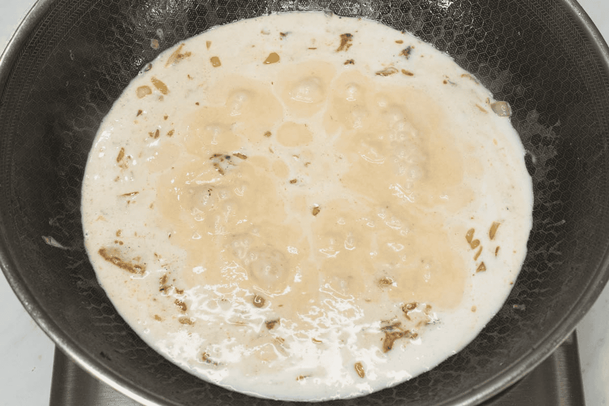 Simmering coconut mixture in a wok.
