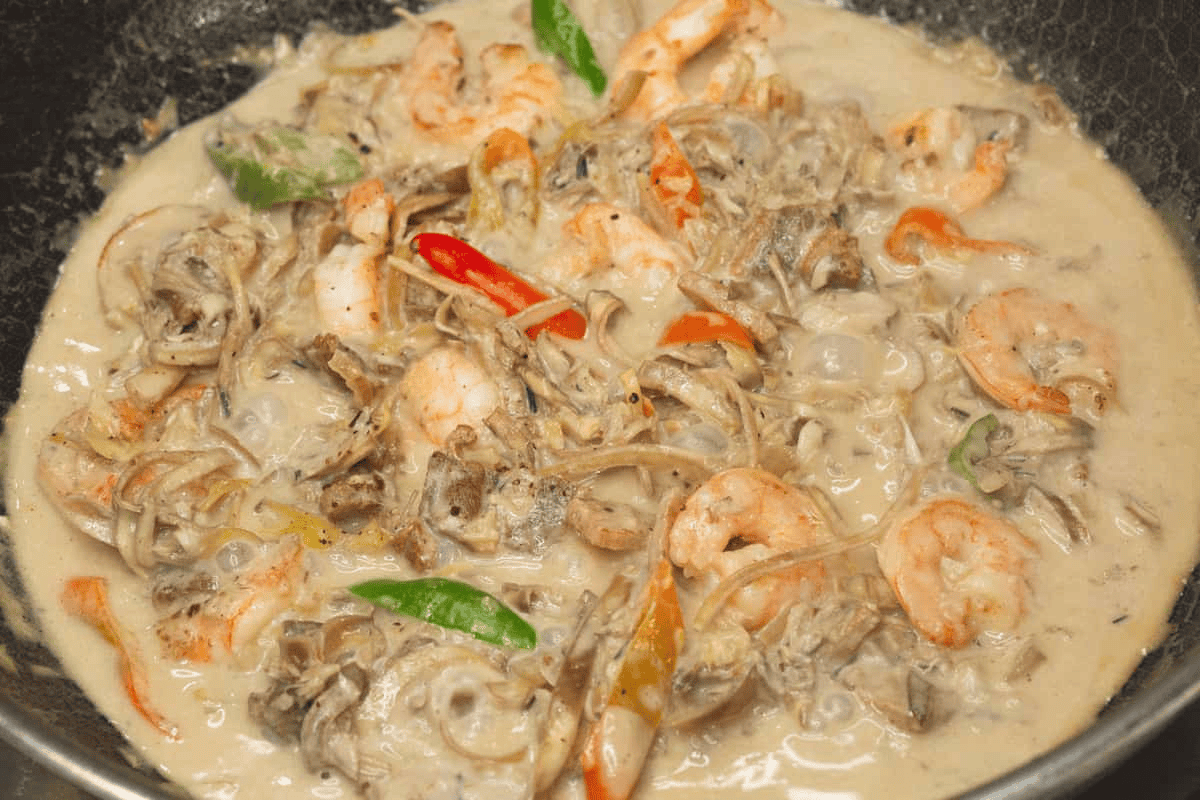 Added shrimp to the simmering mixture in the wok.