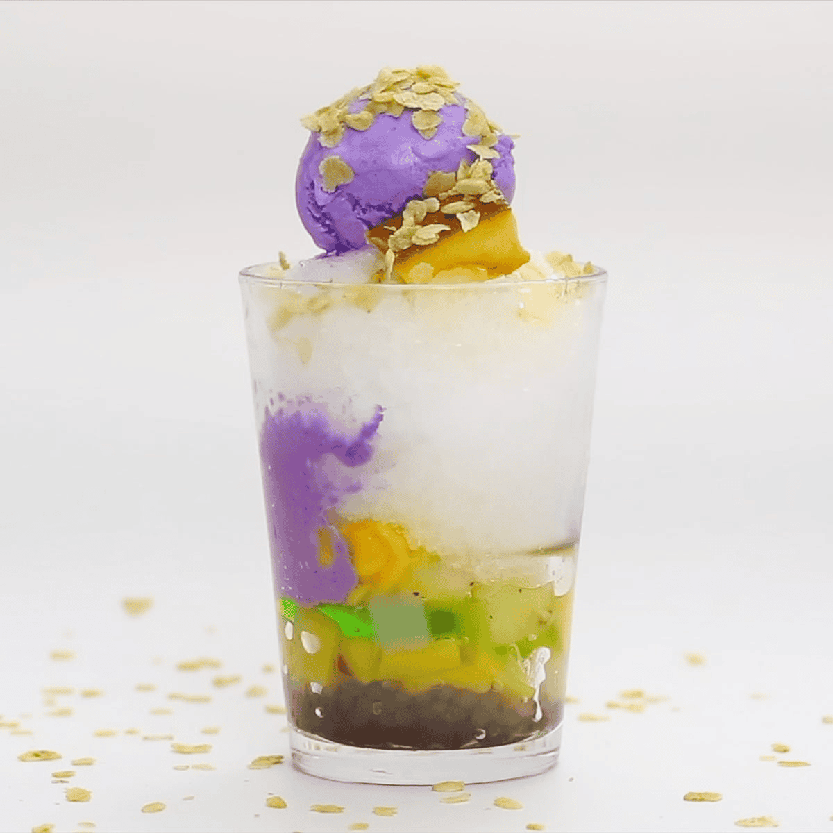Added ube ice cream, leche flan, and pinipig (pounded young rice) to the Halo Halo ingredients in the glass.