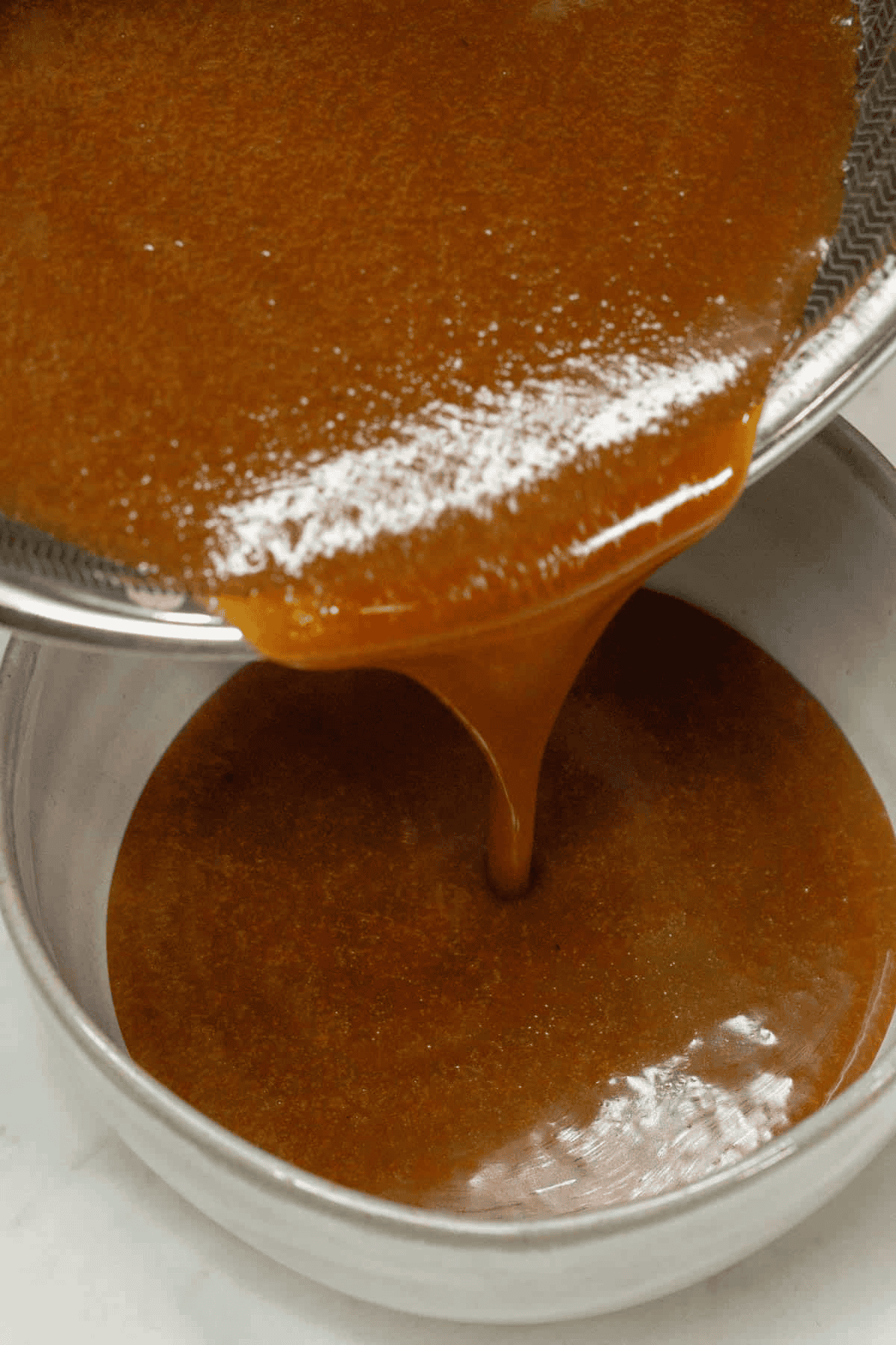 Pouring the latik sauce in the saucepan into the bowl.