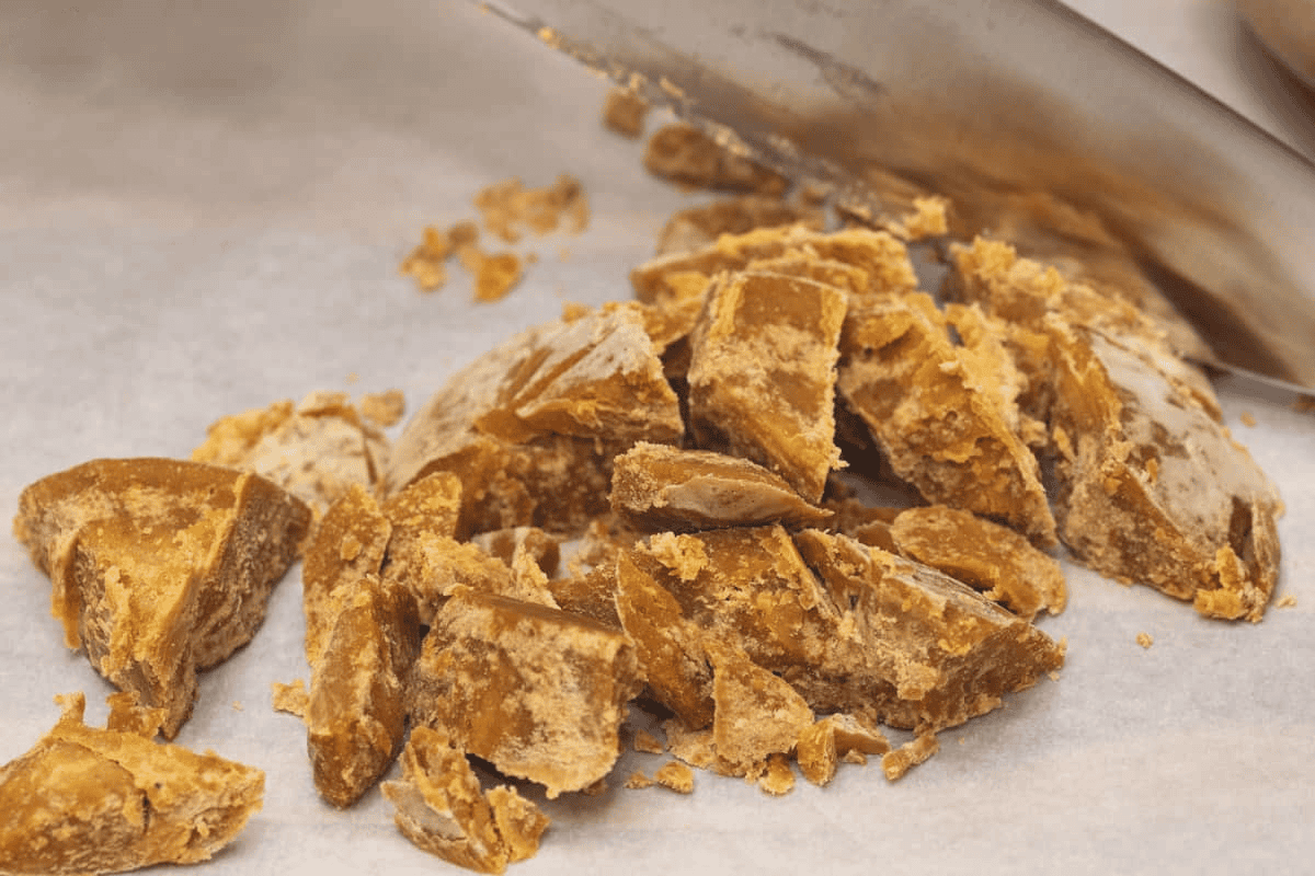 Cutting panutsa into small pieces using a knife.