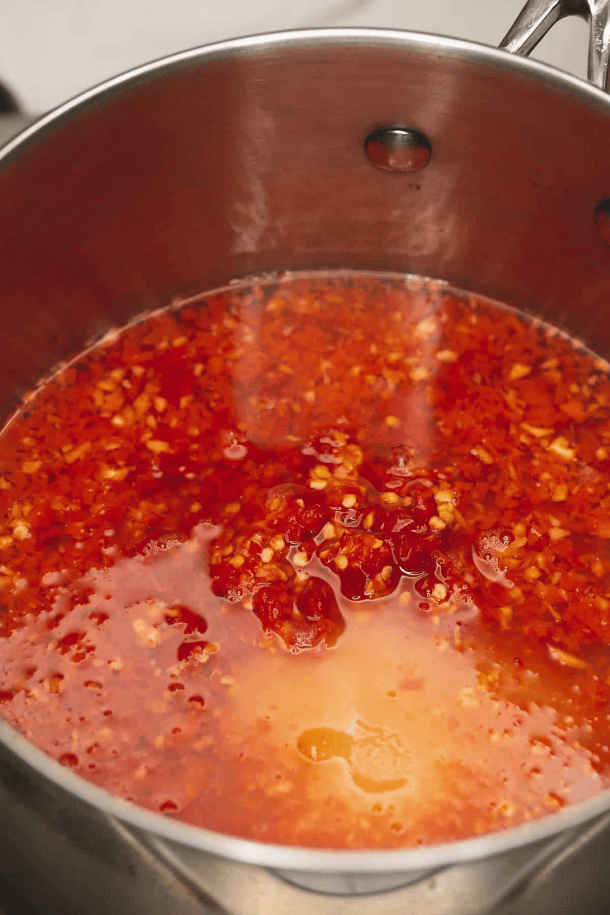 Homemade sweet chili sauce ingredients in a saucepan.